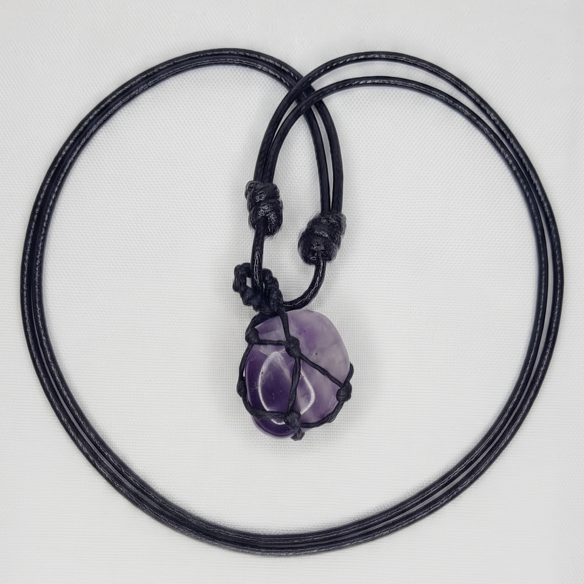 Collar de amatista tejido sobre fondo blanco