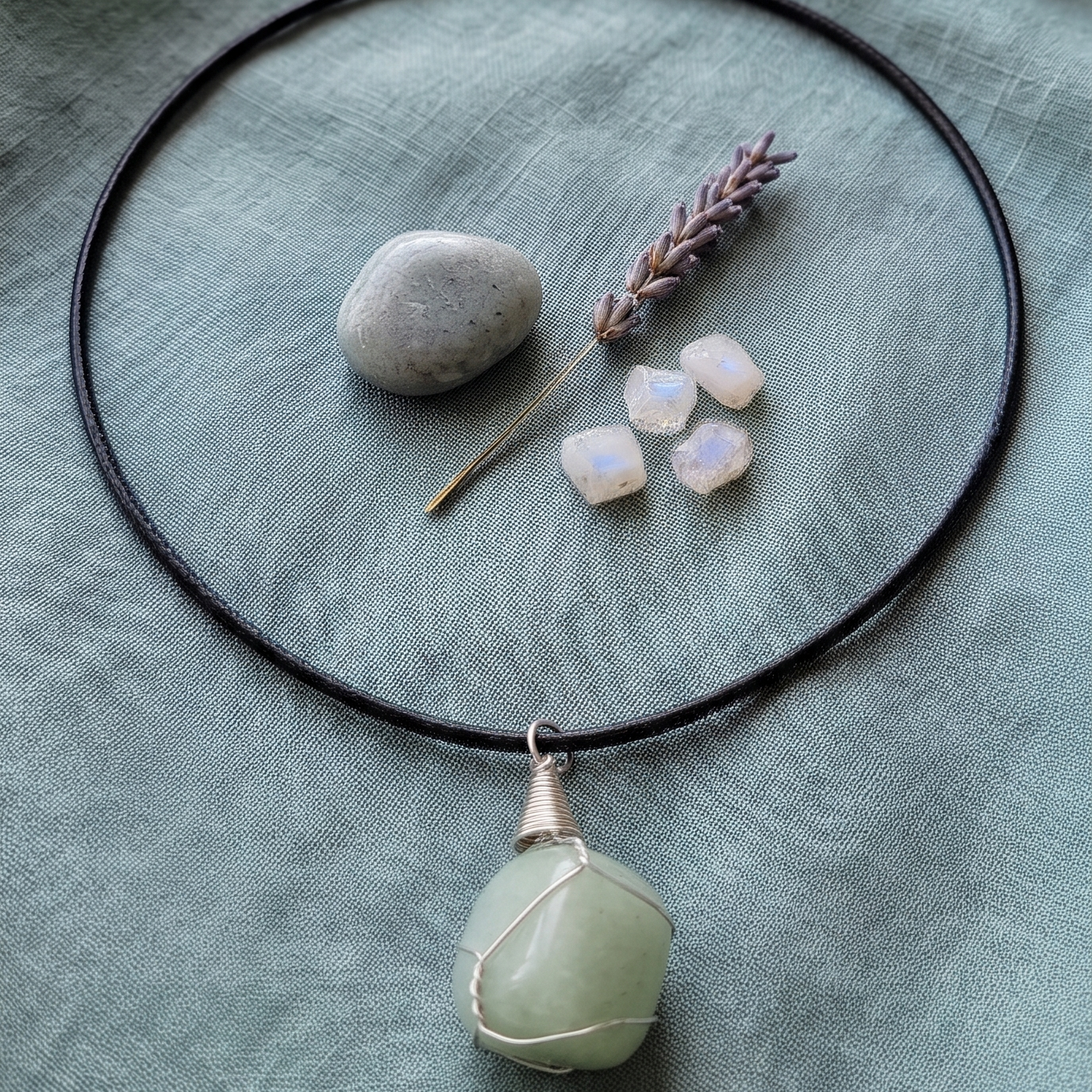 Collar de aventurina verde sobre tela verde con decoración natural